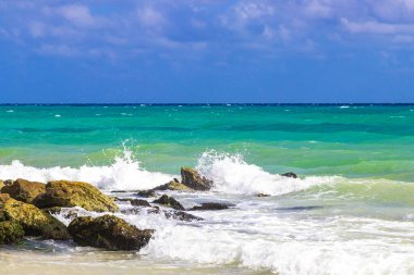 Taşlar, Playacar Playa del Carmen Quintana Roo Meksika 'daki Karayipler sahilinde turkuaz yeşil ve mavi sularda kayalar sallıyor..