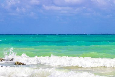 Taşlar, Playacar Playa del Carmen Quintana Roo Meksika 'daki Karayipler sahilinde turkuaz yeşil ve mavi sularda kayalar sallıyor..