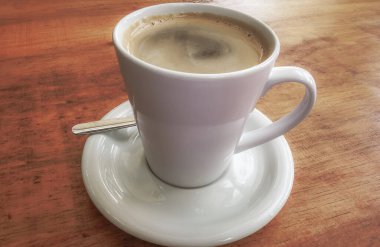 Playa del Carmen Quintana Roo Meksika 'daki restoran kafeteryasında bir tabak kaşık ve tabakla bir bardak koyu americano kahvesi..