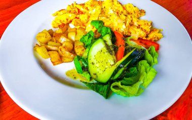 Meksika kahvaltısı ve çırpılmış yumurta ve sebzeler Playa del Carmen Quintana Roo Mexico 'da beyaz tabakta güzelce düzenlenmiştir..