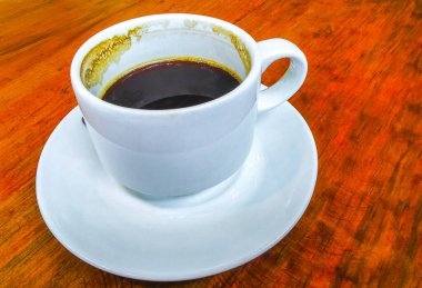 Playa del Carmen Quintana Roo Meksika 'daki restoran kafeteryasında bir tabak kaşık ve tabakla bir bardak koyu americano kahvesi..