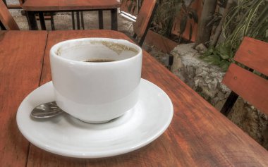 Playa del Carmen Quintana Roo Meksika 'daki restoran kafeteryasında bir tabak kaşık ve tabakla bir bardak koyu americano kahvesi..