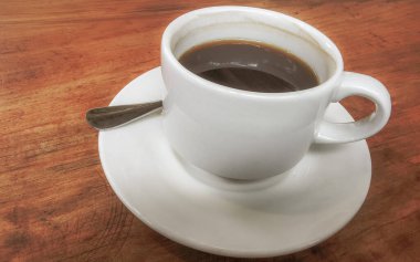 Playa del Carmen Quintana Roo Meksika 'daki restoran kafeteryasında bir tabak kaşık ve tabakla bir bardak koyu americano kahvesi..