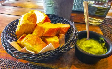 Sepette ekmek ve yeşil kişniş sosu. Playa del Carmen Quintana Roo Meksika 'daki restoranda yemek ve içecek..