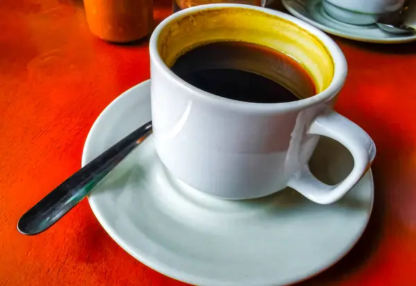 stock image Glass pot cup of americano black coffee with spoon and plate on a table food and drink in the restaurant cafe in Playa del Carmen Quintana Roo Mexico.