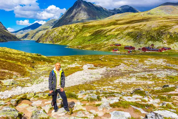 stock image Young hiker traveler photographer with camera and beautiful summer landscape panorama with mountains river lake rocks and hiking trail of Rondane National Park in Ringbu Innlandet Norway in Scandinavia.