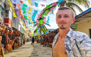 Tipik sokak yolu ve şehir manzarası La Quinta Avenida 'da Quintana Roo Mexico' da Playa del Carmen 'in mağazaları ve binası olan Rus turist erkek..