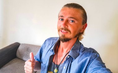 Mutlu ve mutlu gülümseyen genç adam Playa del Carmen Quintana Roo Mexico 'daki dairesinde mavi gözlü..