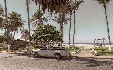 Tipik güzel, renkli turist caddesi yolu ve sahil sahilinde kaldırım şehir arabalarıyla trafik binaları oteller restoranlar ve Zicatela Mexico 'daki insanlar..