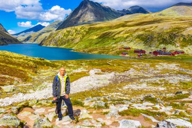 Kameralı genç gezgin fotoğrafçı ve dağlık nehir kayaları ve İskandinavya 'daki Ringbu Innlandet Norveç' teki Rondane Ulusal Parkı 'nın yürüyüş yolu ile güzel bir yaz manzarası..