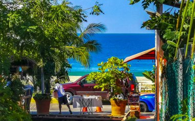 Restaurant restaurants bar bars shops hotels palms palm trees and promenades on the beach in Zicatela Puerto Escondido Oaxaca Mexico. clipart