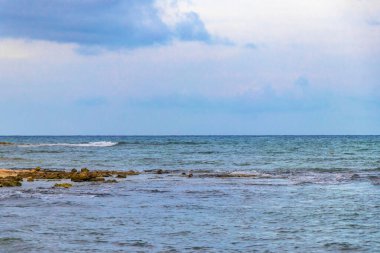 İnsanlarla dolu tropik Meksika Karayip plajı ve denizi güneş şemsiyeleri Playa del Carmen Quintana Roo Meksika 'da turkuaz su ve dalgalar oluşturur..