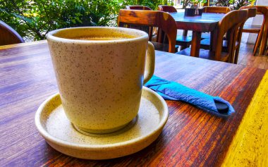 Playa del Carmen Quintana Roo Meksika 'daki restoran kafeteryasında bir tabak kaşık ve tabakla bir bardak koyu americano kahvesi..
