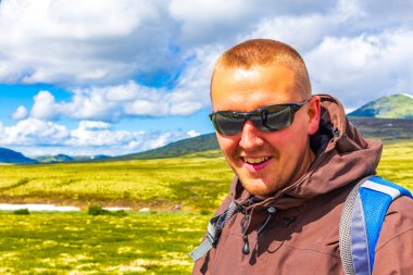 Genç yürüyüşçü ve güzel yaz manzarası dağları, nehir kayaları ve İskandinavya 'daki Ringbu Innlandet Norveç' teki Rondane Ulusal Parkı 'nın yürüyüş yolu..