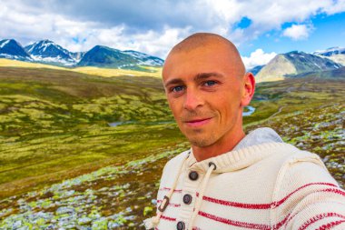 Genç yürüyüşçü ve güzel yaz manzarası dağları, nehir kayaları ve İskandinavya 'daki Ringbu Innlandet Norveç' teki Rondane Ulusal Parkı 'nın yürüyüş yolu..