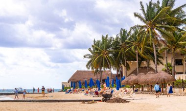 Bir sürü eğlenceli insanla birlikte tropik Meksika Karayip plajı ve denizi. Güneş şemsiyeleri. Playa del Carmen Meksika 'da turkuaz su otelleri..