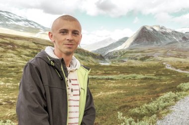 Genç yürüyüşçü ve güzel yaz manzarası dağları, nehir kayaları ve İskandinavya 'daki Ringbu Innlandet Norveç' teki Rondane Ulusal Parkı 'nın yürüyüş yolu..