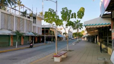 Tipik renkli turist caddesi yolu ve şehir arabalarıyla kaldırım oteller, restoranlar ve Zicatela Mexico 'daki insanlar..