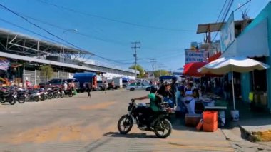Tipik renkli turist caddesi yolu ve şehir arabalarıyla kaldırım oteller, restoranlar ve Zicatela Mexico 'daki insanlar..