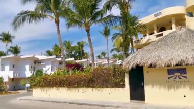 Tipik renkli turist caddesi yolu ve şehir arabalarıyla kaldırım oteller, restoranlar ve Zicatela Mexico 'daki insanlar..