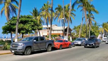 Tipik renkli turist caddesi yolu ve şehir arabalarıyla kaldırım oteller, restoranlar ve Zicatela Mexico 'daki insanlar..