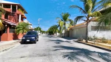 Tipik ve renkli paradisiacal cadde evler, daireler oteller, palmiye ağaçları ve Puerto Escondido Oaxaca Meksika 'daki insanlar..