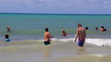 Playa del Carmen Mexico 'daki turkuaz mavi sularda yüzen insanlarla dolu tropik Meksika Karayip plajları ve denizleri..