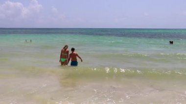 Playa del Carmen Mexico 'daki turkuaz mavi sularda yüzen insanlarla dolu tropik Meksika Karayip plajları ve denizleri..