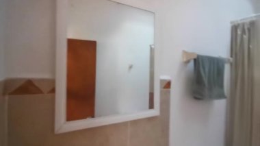 Banyoda aynanın önünde telefonu olan adam Playa del Carmen Quintana Roo Meksika 'da kapıyı kapatıyor..