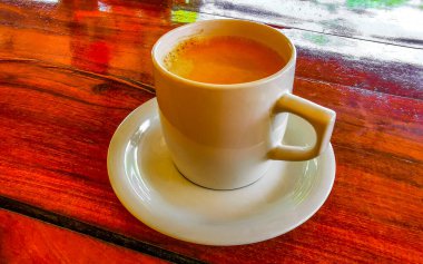 Playa del Carmen Quintana Roo Meksika 'daki restoran kafeteryasında bir tabak kaşık ve tabakla bir bardak koyu americano kahvesi..