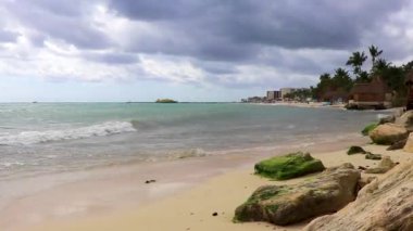 Tropik Meksika Karayip plajı ve denizi kulübeleriyle kulübeleriyle çatı palapa güneşiyle güneşleniyor güneş şemsiyeleriyle turkuaz su otelleri Playa del Carmen Meksika 'da tatil yapıyor..