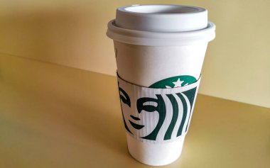 Alajuela Eyaleti Alajuela Kosta Rika 06. Şubat 2021 Beyaz, Orta Amerika 'da Alajuela Kosta Rika' da tahta bir masanın üzerinde Starbucks 'tan bir fincan siyah Americano getirecek..