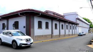 Trafik kaldırımları olan tipik cadde araba mağazaları ve Orta Amerika Alajuela Kosta Rika 'daki insanlar.