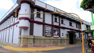 Trafik kaldırımları olan tipik cadde araba mağazaları ve Orta Amerika Alajuela Kosta Rika 'daki insanlar.