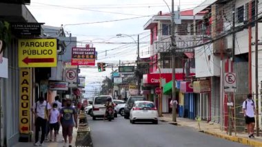 Trafik kaldırımları olan tipik cadde araba mağazaları ve Orta Amerika Alajuela Kosta Rika 'daki insanlar.