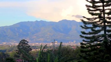 Orman ağaçları, bulutlar ve Orta Amerika 'daki San Jos ve Heredia Kosta Rika' nın doğasıyla güzel bir dağ manzarası ve şehir manzarası..