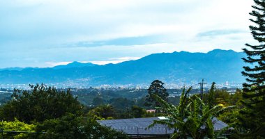 Güneşin doğuşu ve gecenin güzel manzarası dağ manzarası ve şehir orman ağaçları bulutları ve Orta Amerika 'da San Jose ve Heredia Kosta Rika' nın doğası..