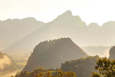 Güneydoğu Asya 'daki Vang Vieng Vientiane Eyaleti Laos' ta tropikal orman tepeleri kayalar ve mavi gökyüzü ile dağ zirvesi..