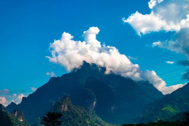 Güneydoğu Asya 'daki Vang Vieng Vientiane Eyaleti Laos' ta tropikal orman tepeleri kayalar ve mavi gökyüzü ile dağ zirvesi..