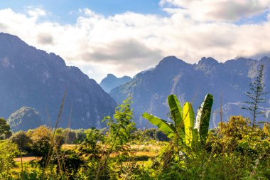 Güneydoğu Asya 'daki Vang Vieng Vientiane Eyaleti Laos' ta tropikal orman tepeleri kayalar ve mavi gökyüzü ile dağ zirvesi..
