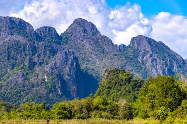 Güneydoğu Asya 'daki Vang Vieng Vientiane Eyaleti Laos' ta tropikal orman tepeleri kayalar ve mavi gökyüzü ile dağ zirvesi..