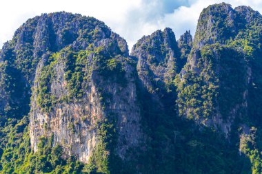Güneydoğu Asya 'daki Vang Vieng Vientiane Eyaleti Laos' ta tropikal orman tepeleri kayalar ve mavi gökyüzü ile dağ zirvesi..