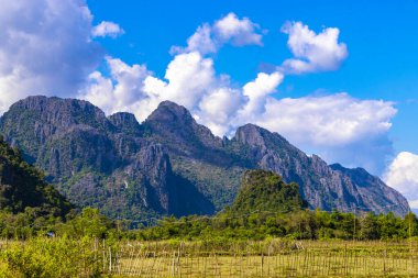 Güneydoğu Asya 'daki Vang Vieng Vientiane Eyaleti Laos' ta tropikal orman tepeleri kayalar ve mavi gökyüzü ile dağ zirvesi..