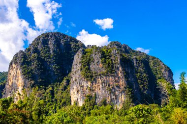 Güneydoğu Asya 'daki Vang Vieng Vientiane Eyaleti Laos' ta tropikal orman tepeleri kayalar ve mavi gökyüzü ile dağ zirvesi..