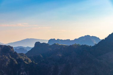 Güneydoğu Asya 'daki Vang Vieng Vientiane Eyaleti Laos' ta tropikal orman tepeleri kayalar ve mavi gökyüzü ile dağ zirvesi..