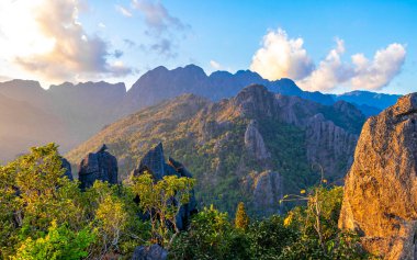 Tropikal orman tepeleriyle dağ zirvesi kayaları ve Southeastasia Asia 'daki Vang Vieng Vientiane Vientiane Eyaleti Laos' ta inanılmaz renkli altın gün batımı..