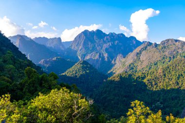 Güneydoğu Asya 'daki Vang Vieng Vientiane Eyaleti Laos' ta tropikal orman tepeleri kayalar ve mavi gökyüzü ile dağ zirvesi..