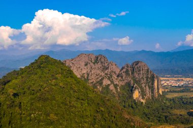 Güneydoğu Asya 'daki Vang Vieng Vientiane Eyaleti Laos' ta tropikal orman tepeleri kayalar ve mavi gökyüzü ile dağ zirvesi..