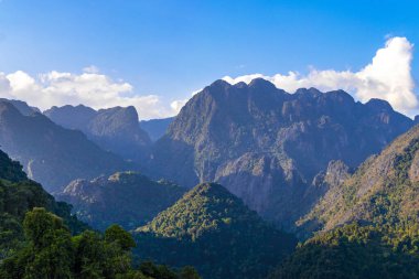 Güneydoğu Asya 'daki Vang Vieng Vientiane Eyaleti Laos' ta tropikal orman tepeleri kayalar ve mavi gökyüzü ile dağ zirvesi..