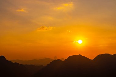 Tropikal orman tepeleriyle dağ zirvesi kayaları ve Southeastasia Asia 'daki Vang Vieng Vientiane Vientiane Eyaleti Laos' ta inanılmaz renkli altın gün batımı..